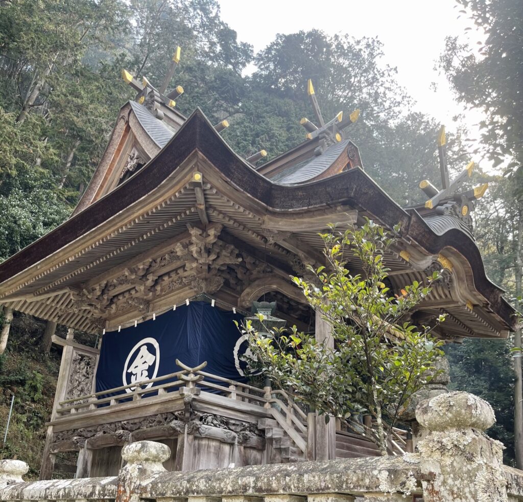 「丸に金」の紋の幕が掛かる大歳金刀比羅神社の社殿